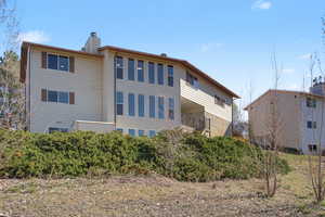 Rear view of house featuring a chimney and a balcony