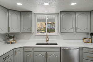 Kitchen with dishwasher, gray cabinetry, light stone countertops, a textured ceiling, and recessed lighting