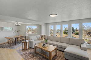 Living room with wood finished floors, a textured ceiling, and hanging lights