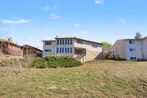 Back of property featuring a yard and a balcony
