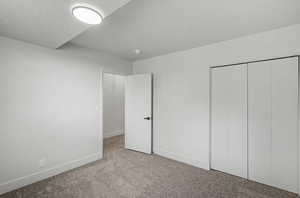 Unfurnished bedroom with carpet flooring and a closet