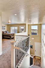 Stairs with recessed lighting and a textured ceiling