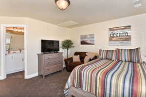 Bedroom featuring dark carpet and connected bathroom