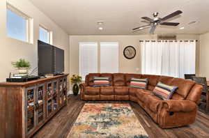 Living room featuring ceiling fan, dark wood-style flooring, recessed lighting, and a textured ceiling