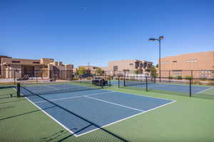 View of tennis court with a residential view