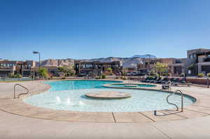 Community pool with a patio area, a residential view, and a hot tub