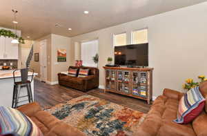 Living room featuring dark wood-style floors and baseboards