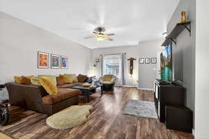 Living area with dark wood finished floors and ceiling fan