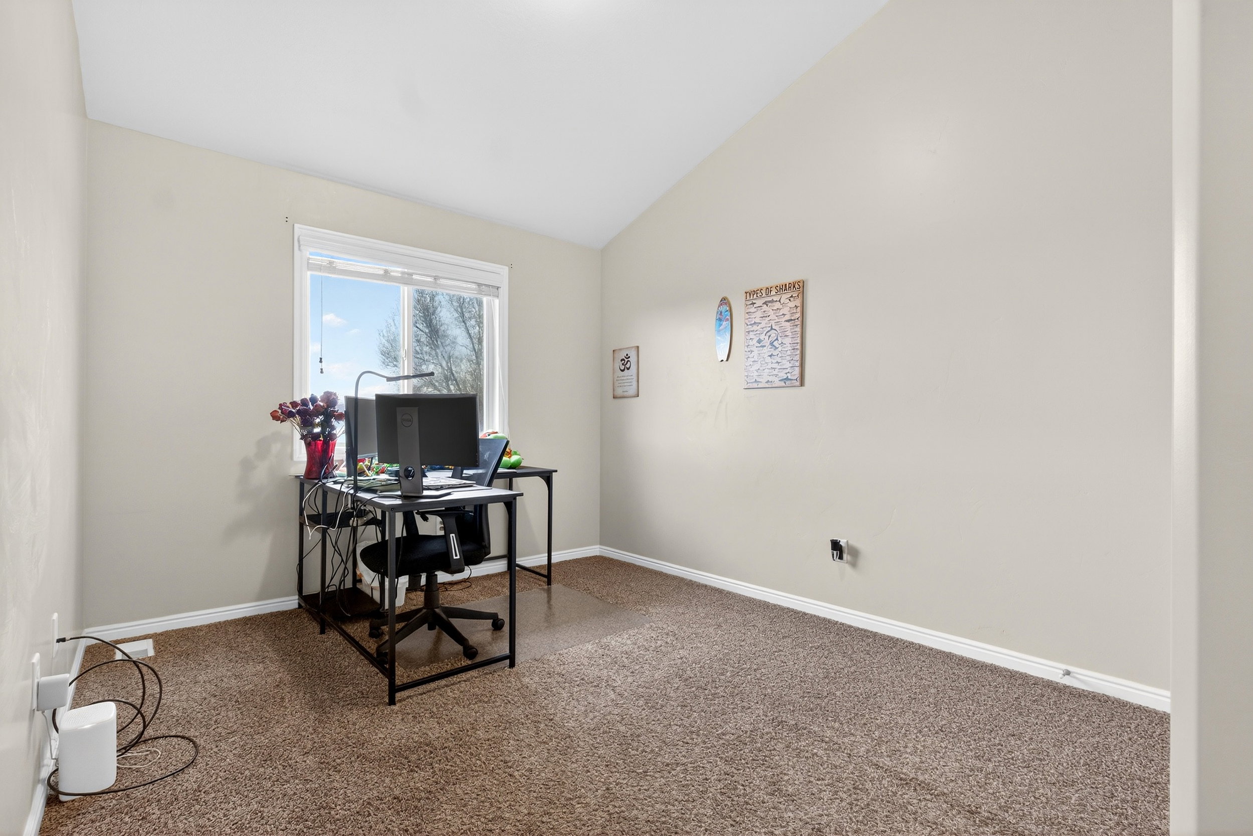 Office area featuring vaulted ceiling and carpet
