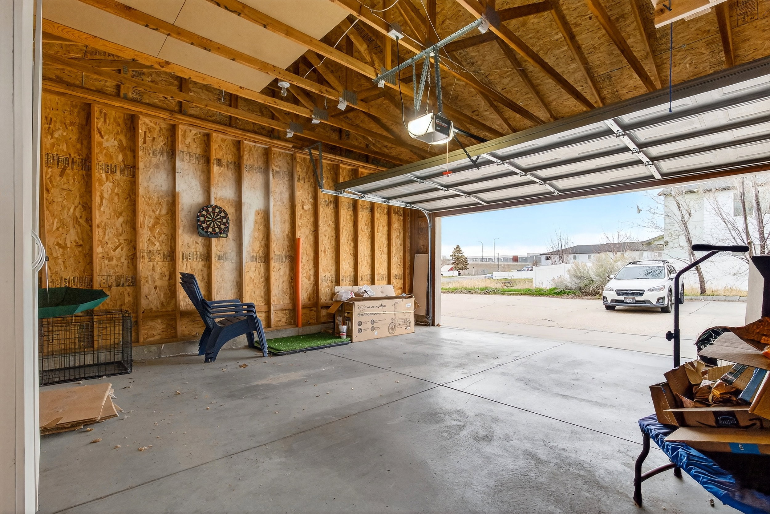 Garage featuring a garage door opener and a residential view