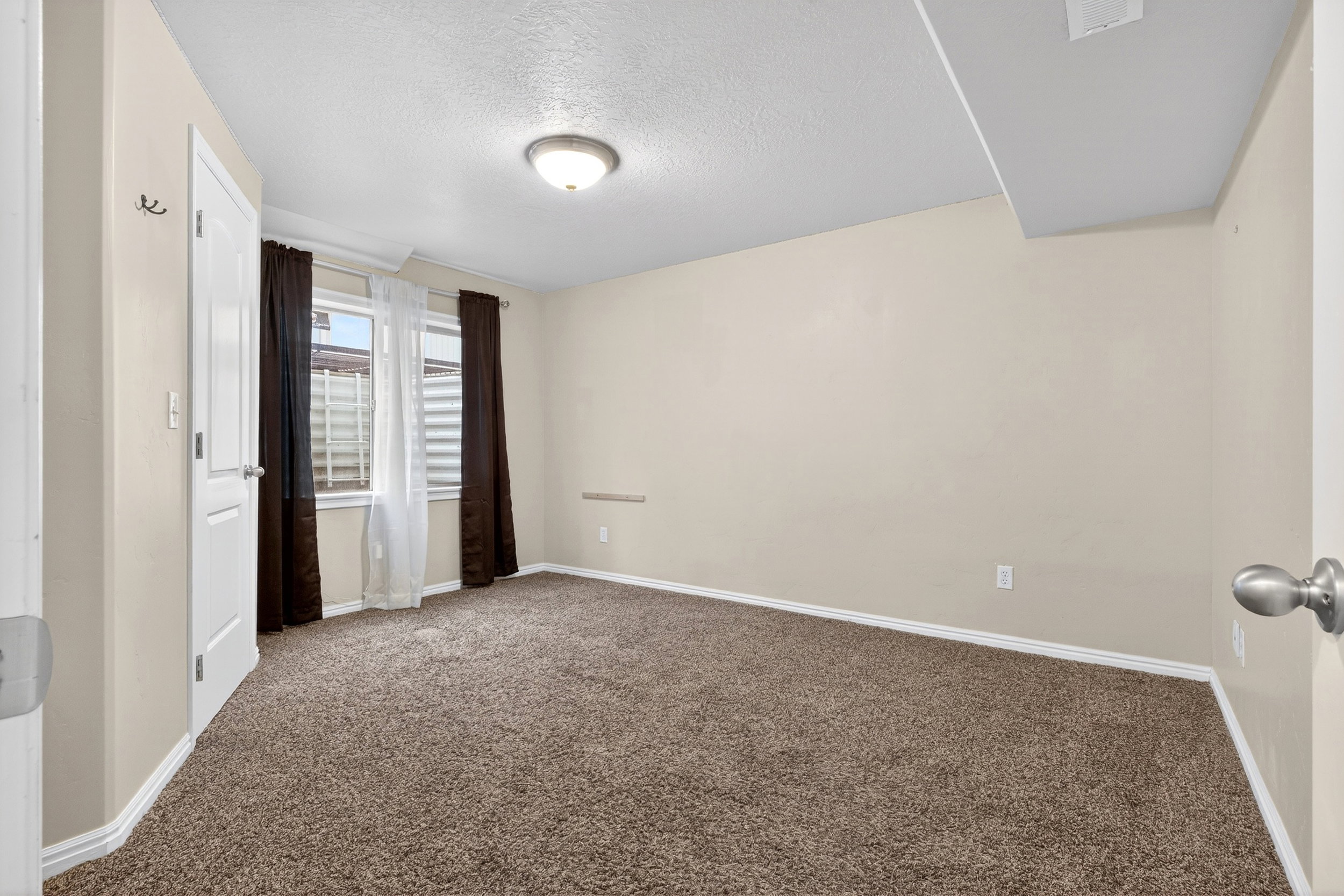 Unfurnished bedroom featuring a textured ceiling and dark carpet