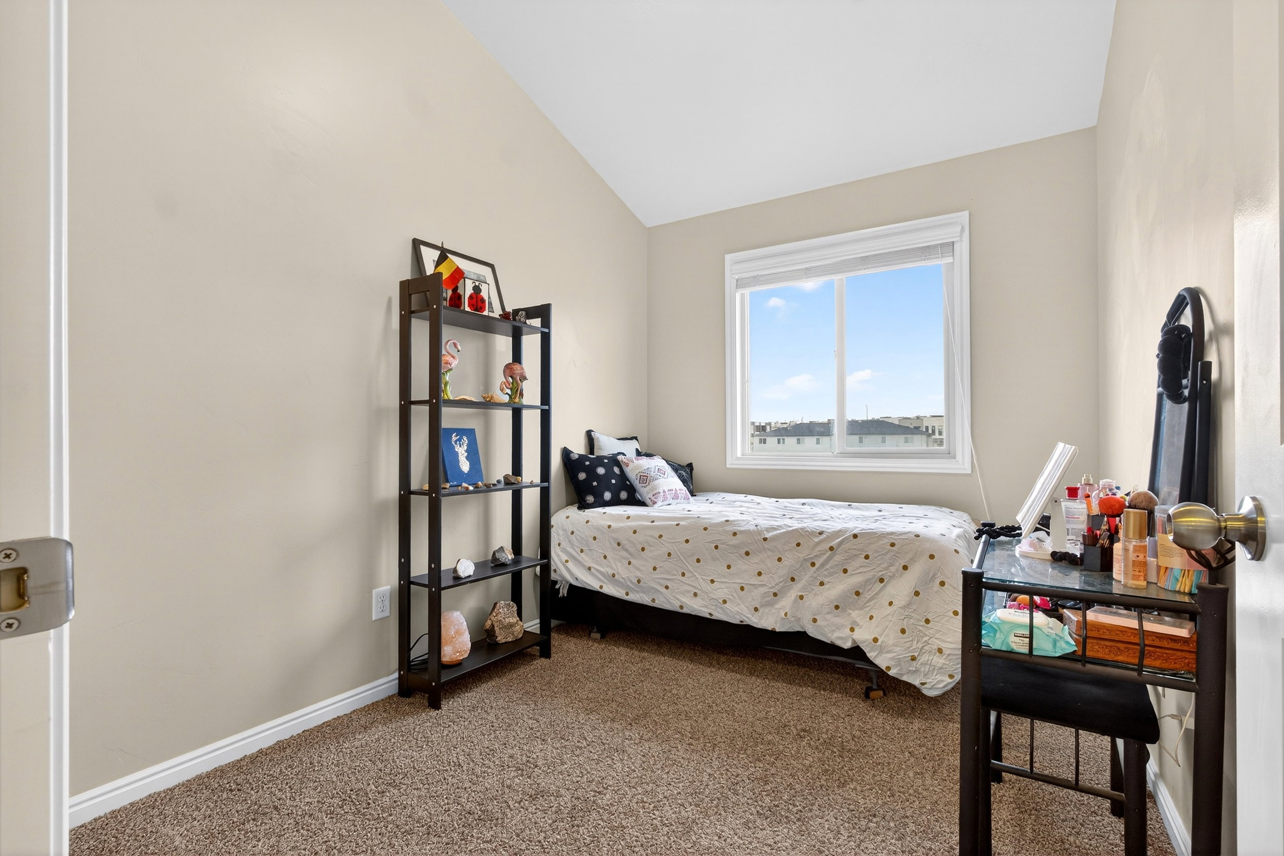 Carpeted bedroom with vaulted ceiling and baseboards