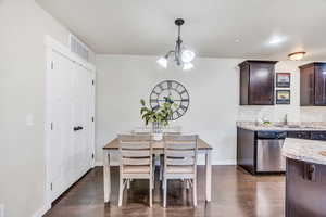 Dining space featuring hanging lights and dark wood-style floors