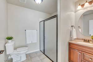 Bathroom with a shower stall, vanity, and light tile patterned floors