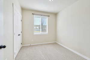 Unfurnished bedroom featuring light colored carpet and a closet