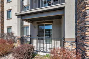Entrance to property featuring stucco siding and stone siding