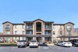 View of apartment building / complex with covered parking and stairs