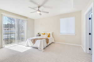 Carpeted bedroom featuring access to outside and ceiling fan