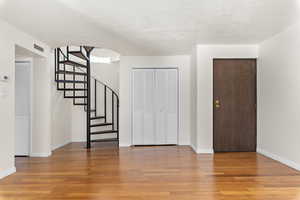 Foyer entrance with light wood-style flooring and arched walkways