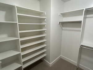 Walk in closet featuring dark colored carpet