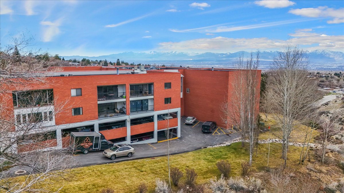 View of apartment building / complex featuring uncovered parking
