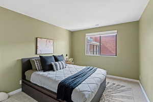 Bedroom featuring light carpet and baseboards