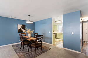 Dining room featuring light colored carpet and baseboards