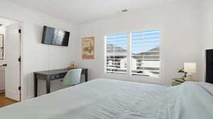 Bedroom with ensuite bath and wood finished floors