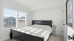 Bedroom featuring light carpet and baseboards