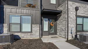 View of exterior entry featuring board and batten siding and stone siding