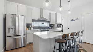Kitchen featuring stainless steel appliances, white cabinets, a breakfast bar, and dark wood-type flooring