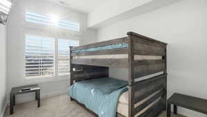 Bedroom featuring light carpet and baseboards