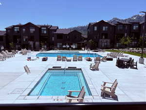 Community pool featuring a mountain view and a patio
