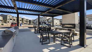 View of patio featuring a pergola, an outdoor kitchen / dining area, and a residential view