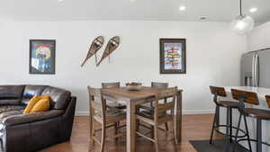 Dining area featuring dark wood-type flooring and recessed lighting
