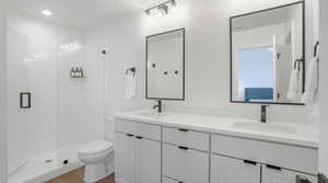 Full bathroom featuring a stall shower, double vanity, dark wood-type flooring, and recessed lighting