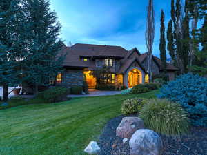 View of front of house featuring a lawn and stone siding