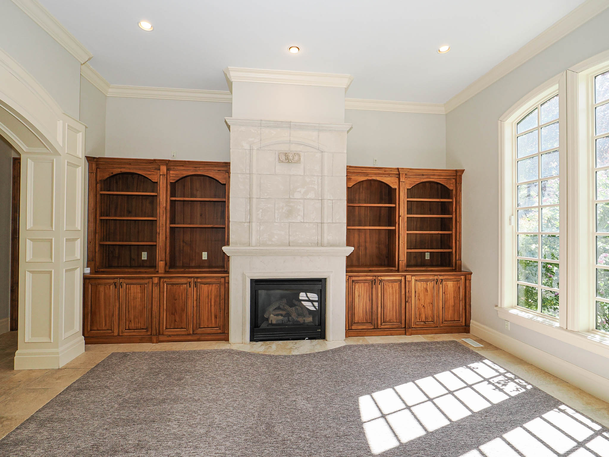 Unfurnished living room with crown molding, a large fireplace, and recessed lighting