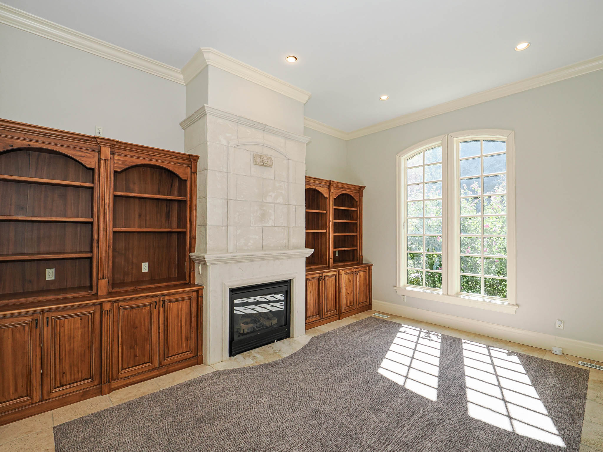 Unfurnished living room with ornamental molding, a fireplace with flush hearth, recessed lighting, and light tile patterned floors