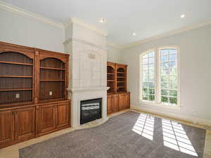 Unfurnished living room with ornamental molding, a fireplace with flush hearth, recessed lighting, and light tile patterned floors