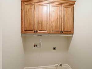 Laundry area with cabinet space, hookup for a washing machine, and electric dryer hookup