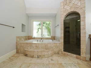 Bathroom with a garden tub, a shower stall, and vanity