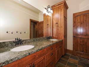 Bathroom with double vanity and baseboards