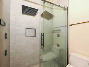 Bathroom featuring toilet and a stall shower