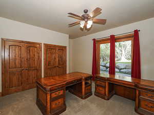 Office space with a ceiling fan and carpet floors