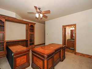 Bedroom featuring light carpet, ceiling fan, and connected bathroom