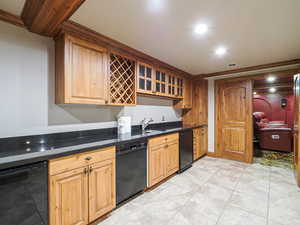 Kitchen featuring dishwasher, recessed lighting, crown molding, glass fronted cabinets, and dark stone counters