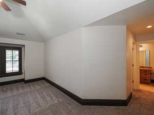 Unfurnished room with dark carpet and ceiling fan