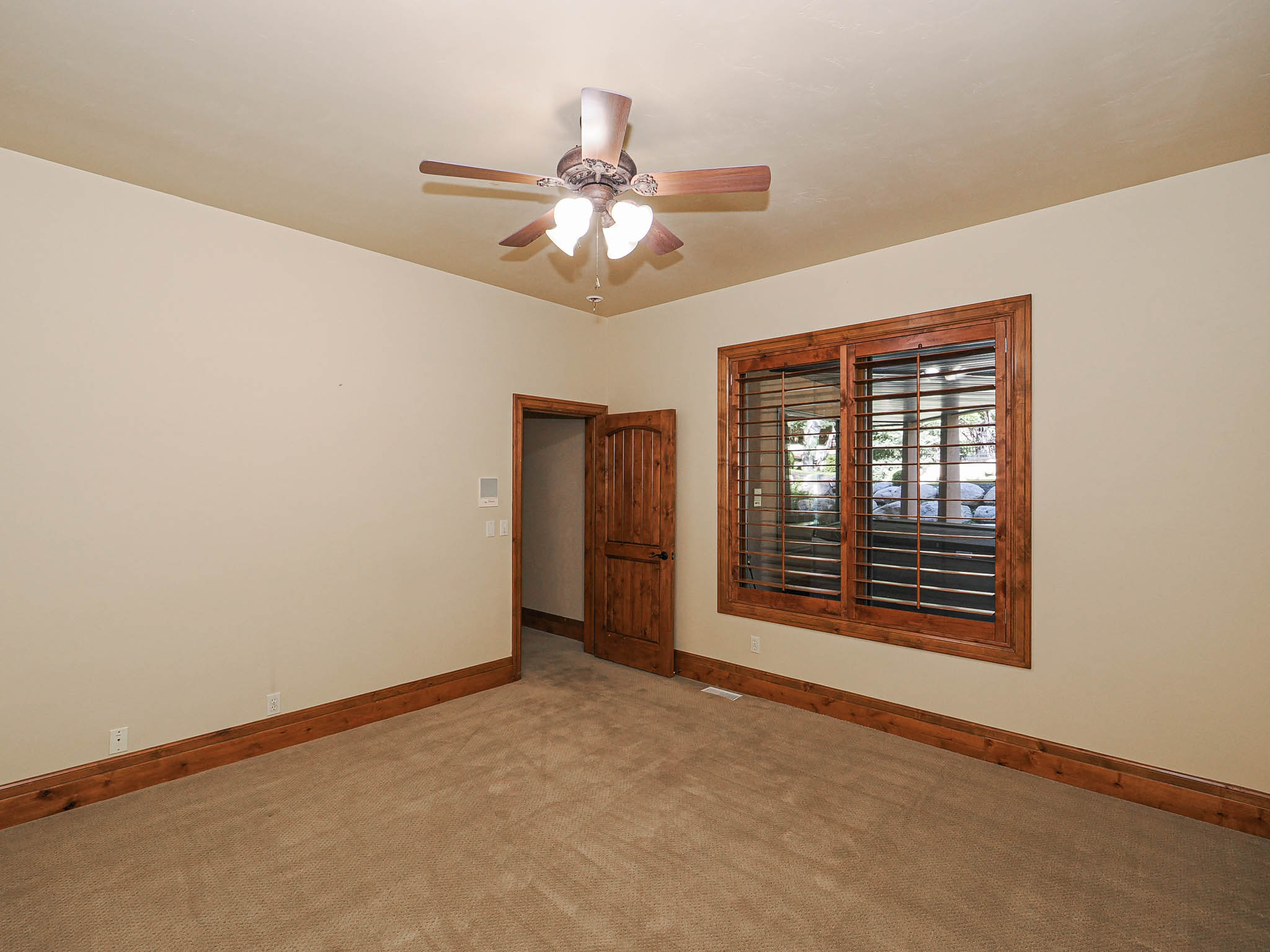 Carpeted empty room featuring baseboards and a ceiling fan