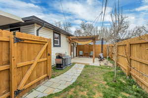 Fenced backyard featuring a gate, a patio area, and a pergola